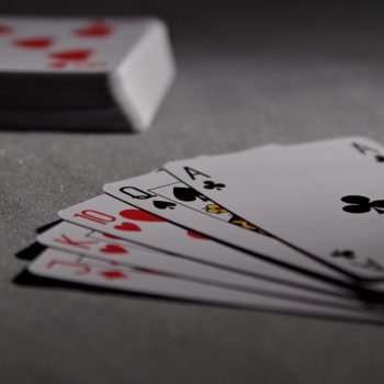 Detailed view of playing cards displaying a winning poker hand in a dimly lit scene.